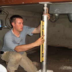 A contractor in Morristown installing a crawl space jack post.