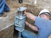 Foundation repair contractors installing the foundation bracket in Johnson City.