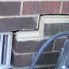 A closeup of a failed tuckpointing job where the brick cracked on a Tri-Cities Area home.
