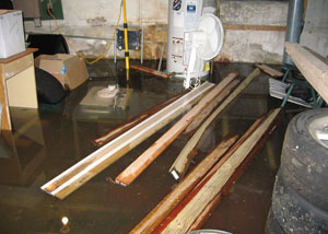A severely flooding basement in Ooltewah, with lumber and personal items floating in a foot of water